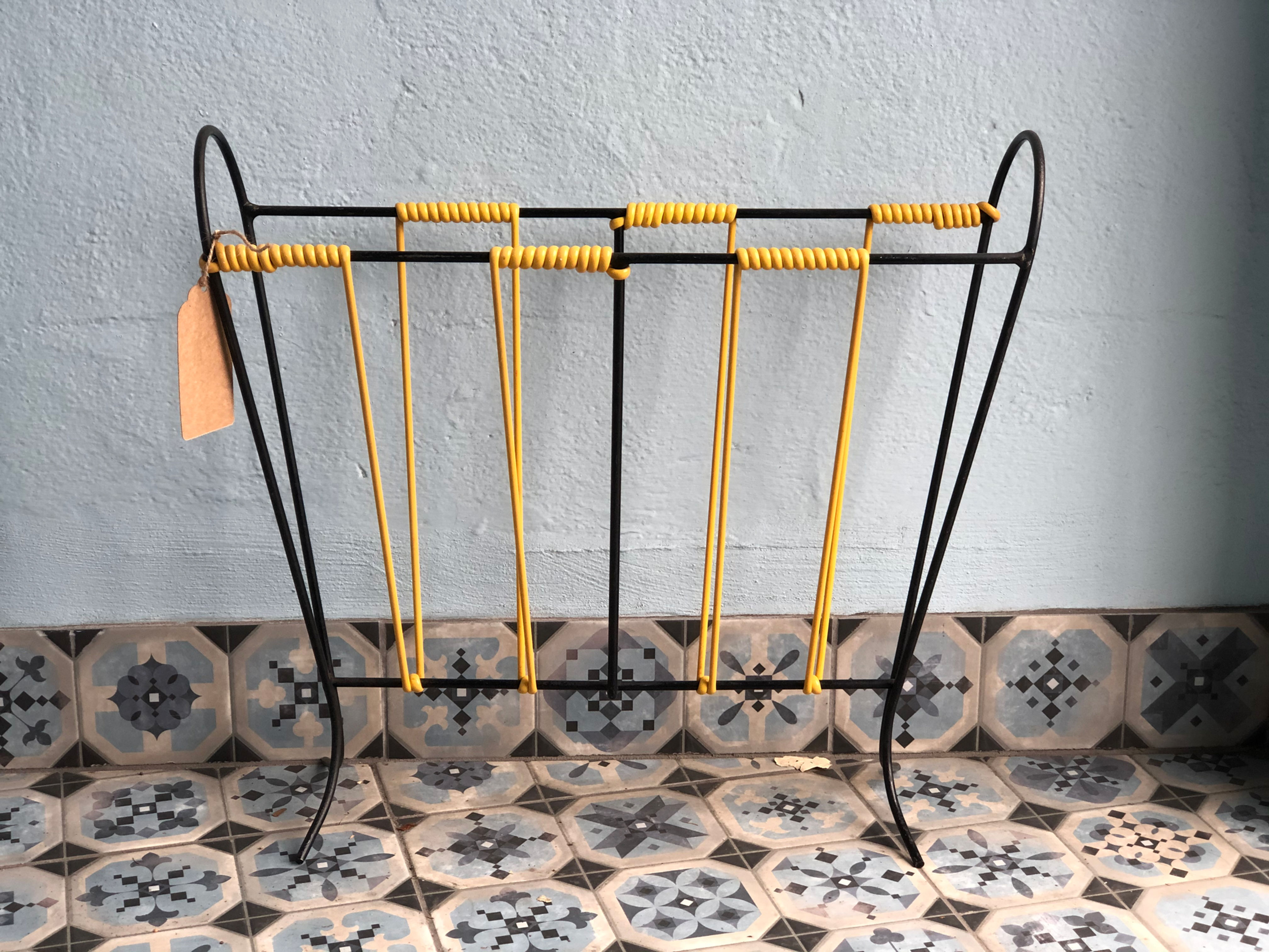 Vintage magazine rack, yellow plastic and black metal.