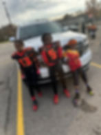 Three boys in football uniforms; positive youth development programs.