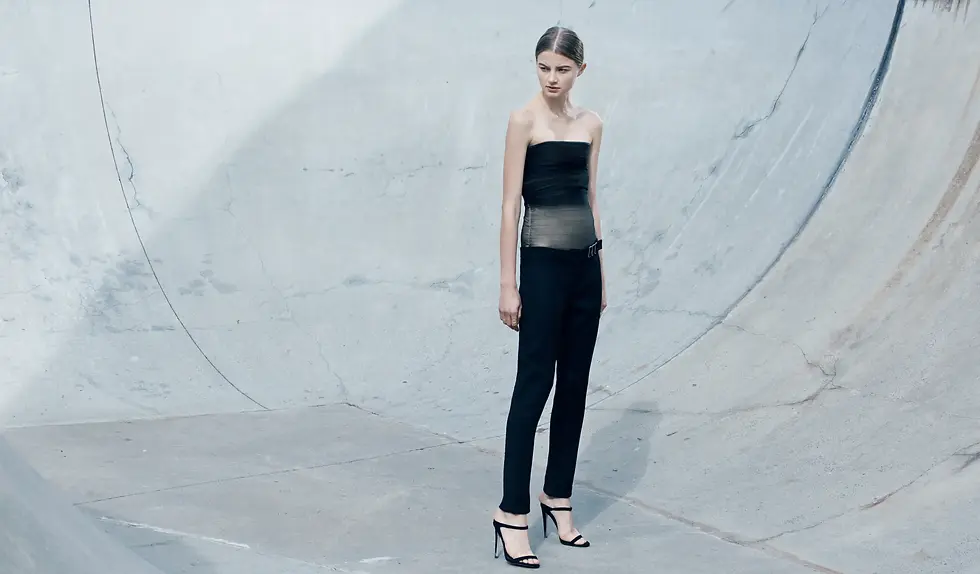 Fashion model in skate park pit wearing neodia gavin lowes silver silk mesh gather bodice in black and cigarette tailored pant with wrap belt