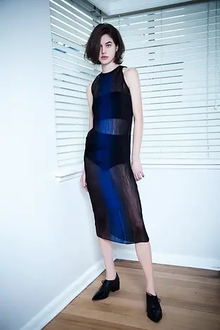 FASHION MODEL IN LIVING ROOM WEARING SHEER PLEATED ORGANZA DRESS WITH OMBRE PRINT BY NEODIA GAVIN LOWES