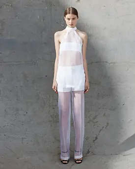 Model in skate park pit wearing white organza tank and pleat pants by GAVIN LOWES NEODIA