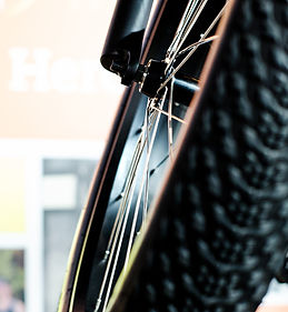 Close-up of a bike tire showing the thick tread pattern and part of the metal wheel rim.