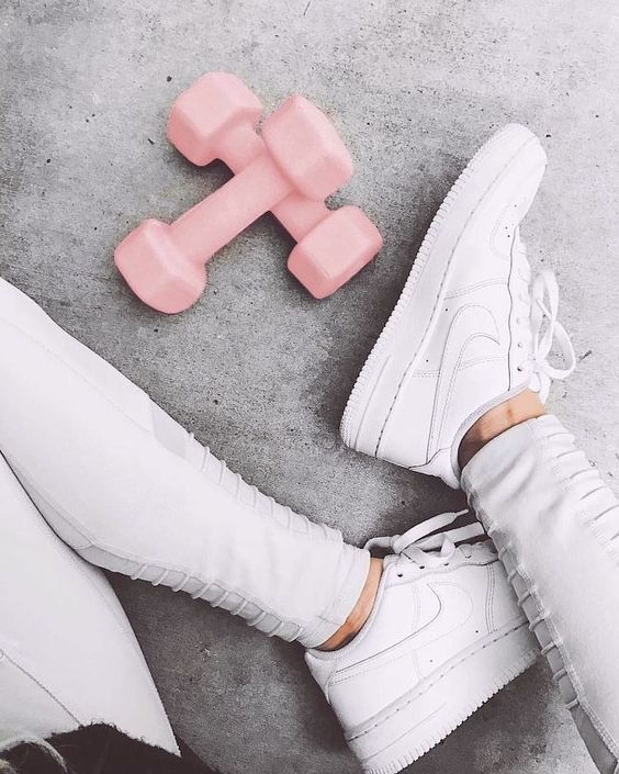 schoenen en roze gewichten op de grond. Hoe je moet beginnen met klrachttraining