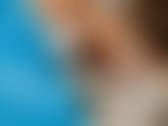 Mujer enferma cubierta con una manta mantiene una consulta de telemedicina desde su sofá, usando una laptop donde una profesional de la salud con audífonos y micrófono la atiende virtualmente.