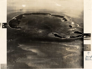 aerial view of islands in a crescent shape with markings on the side of the photo