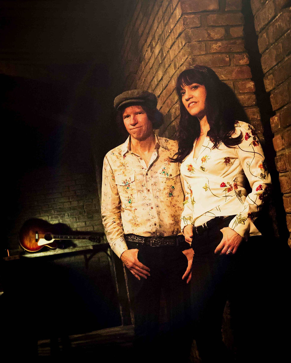 Two peopel standing next to a brick wall