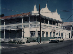 A two story building with turrets, an upstairs porch and a sign that reads sociedad de cuba on the front.