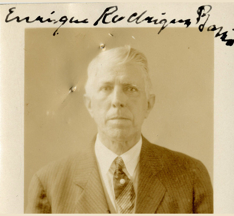 A photograph of a man wearing a coat and tie. Handwriting on photograph reads Enrique Rodriguez Basso.