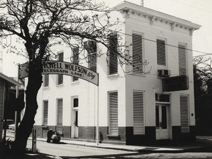 A building with a sign next to it that reads Mitchell Wolfson Way (Telegraph Lane)