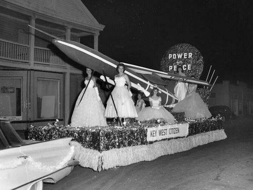 Women wearing ball gowns on a float with a missile and signs reading Power for Peace and Key West Citizen.