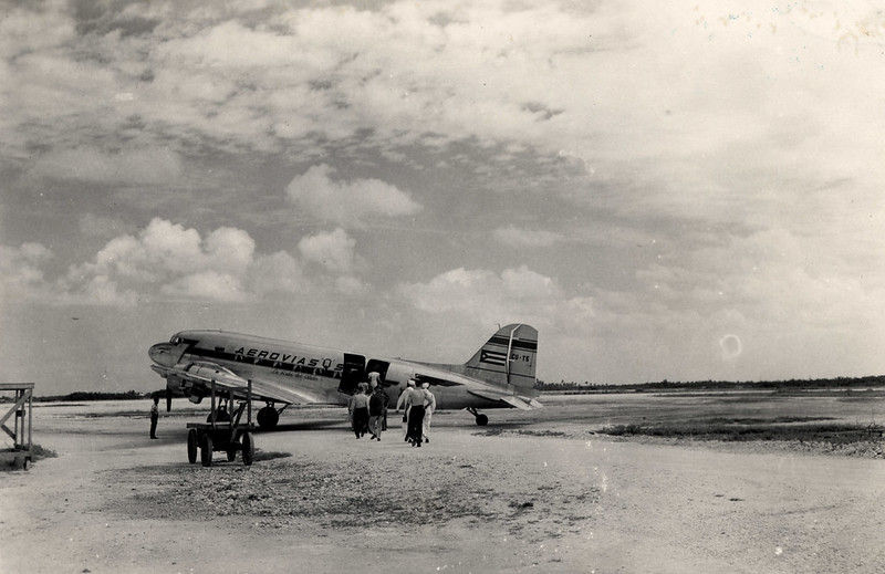 People walking toward a plane with AeroviasQ written on the side