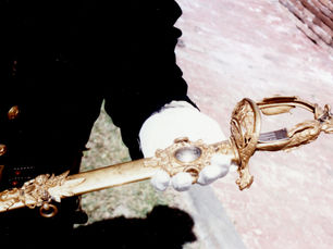 a gold sword held by someone in dress uniform