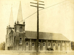 a church made out of concrete blocks with two spires at the front