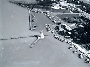 Aerial view of a marina with a small lighthouse on a pier