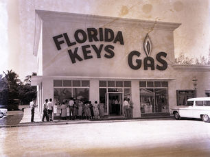People in front of a building with Florida Keys Gas written on the side.