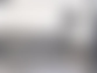 A grocery store with signs offering prices in the window and a sign that reads Fausto's Food Palace.