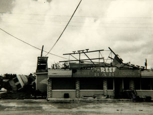 A damaged building with the word REEF on the facade.