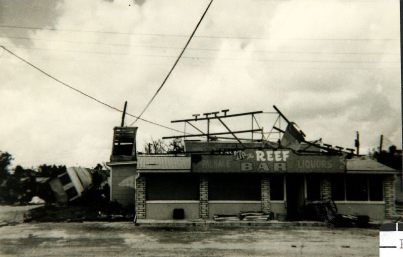 A wrecked building with a sign on the front that says REEF.