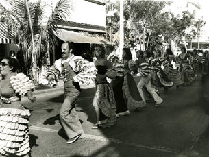 a line of comparsa dancers on the street