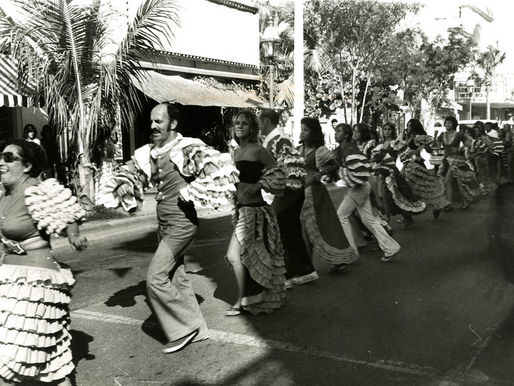 a line of comparsa dancers on the street