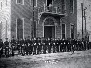 Lines of people in uniform in front of a building. Writing on photo reads By Hunt Key West '07