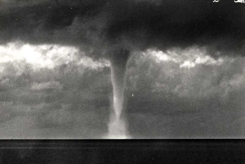 A waterspout descending from clouds to the water.