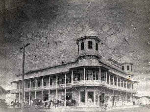 A two-story buildign wtih a cupola at the corner