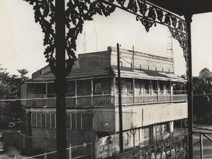 A two story building seen from the balcony of another building across the street.