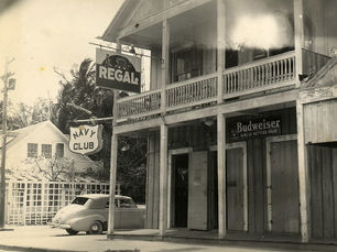 A building with a sign that reads the Regal and another that reads Navy Club