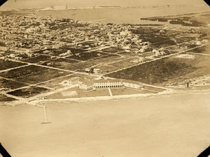 Aerial view of a shoreline with a large building in the foreground.