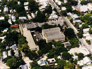 Aerial view of a large masonry building surrounded by streets and smaller buildings