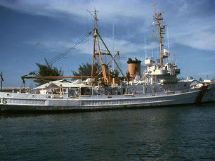 A docked Coast Guard vessel with 85 written on the hull