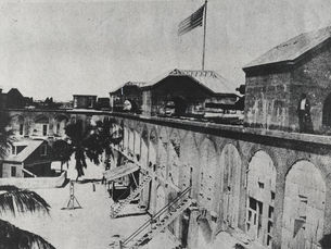 The interior of a fort with several sets of stairs leading to the second level and an American flag flying from the top.