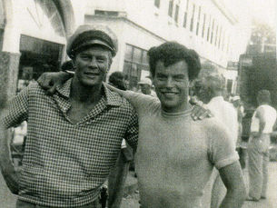 two men standing with their arms around each other's shoulders