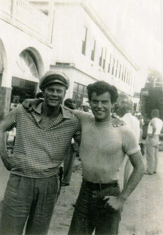 two men standing with their arms around each other's shoulders