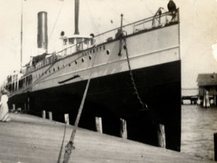 A large ship with olivette written on the side tied up at a dock.
