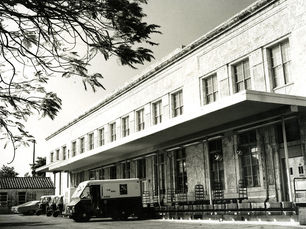 a long building with u.s. mail trucks backed up to it.