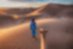 Two Tuareg nomads leading a camel in the