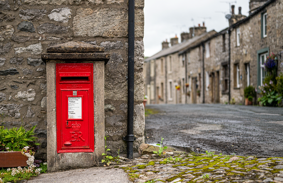 A red post box on a picturesque street in Langcliffe village.