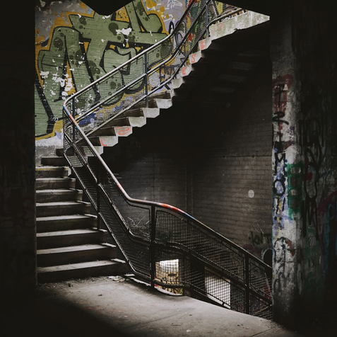 The staircase of an abandoned building with graffiti.