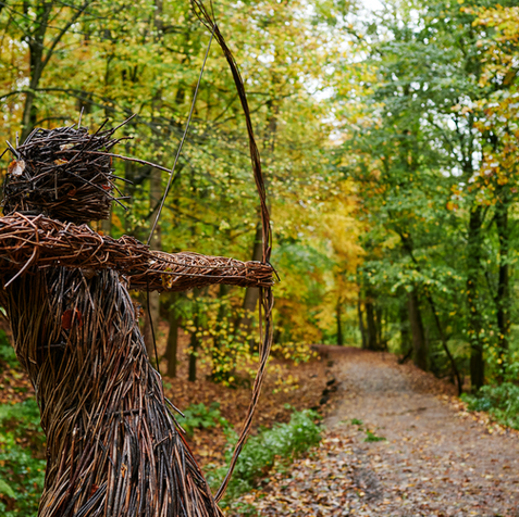 Willow archer statue in an autumnal woodland. 