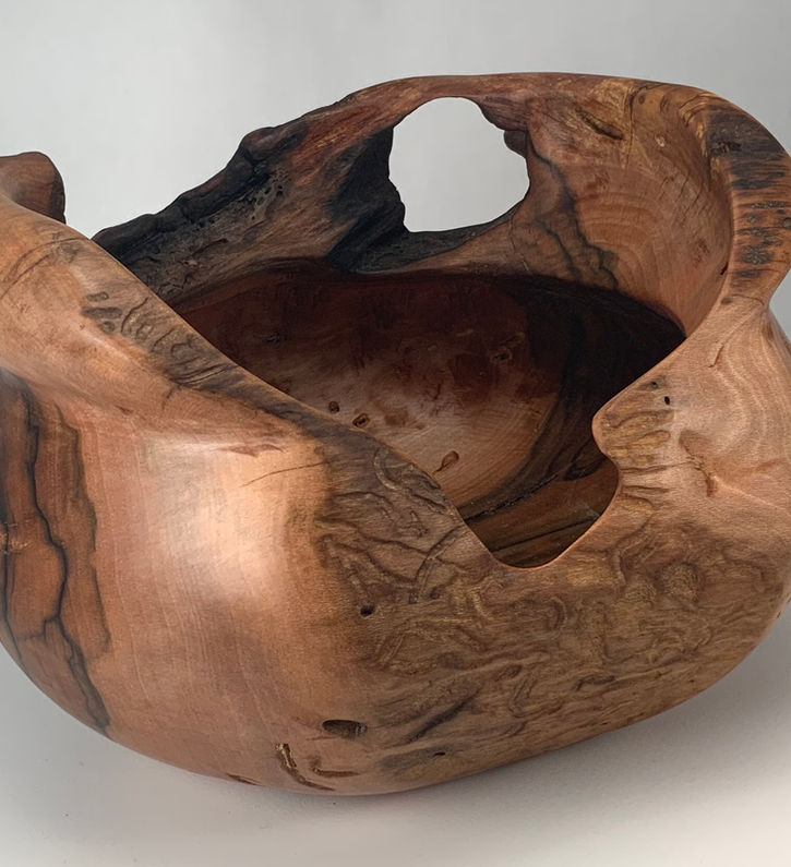 Pinkish bowl made from dogwood with holes and knots