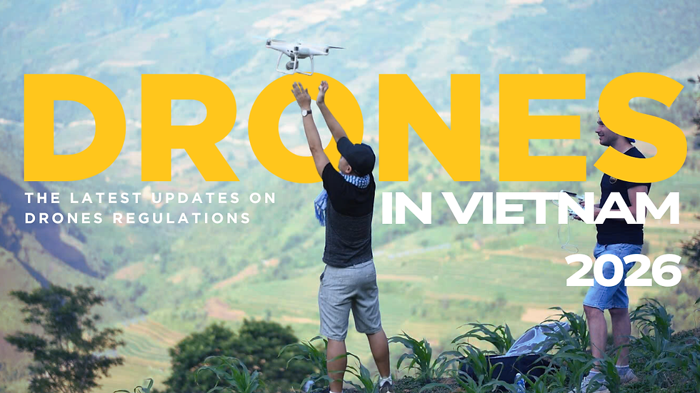 Two men on a hillside fly a drone. One raises arms; the other holds a controller. Scenic mountains and greenery in the background.