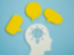 Silhouette of a head with a brain and light bulb cutout, surrounded by yellow speech bubbles on a blue background, symbolizing ideas.