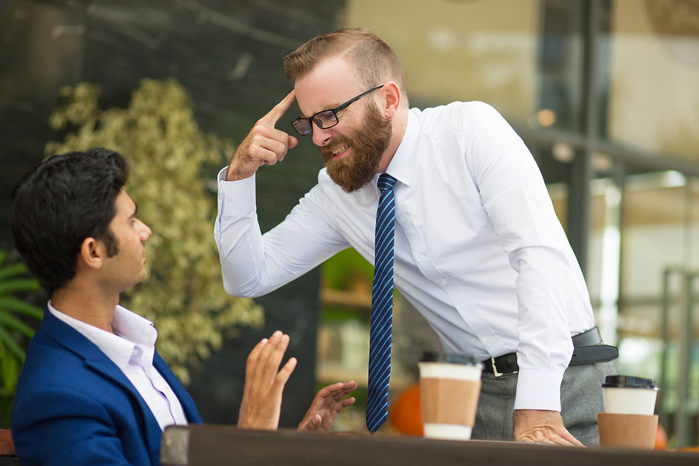Man in white shirt angrily points at sitting man in blue suit. They're at a cafe with coffee cups, plants in background, tense mood.