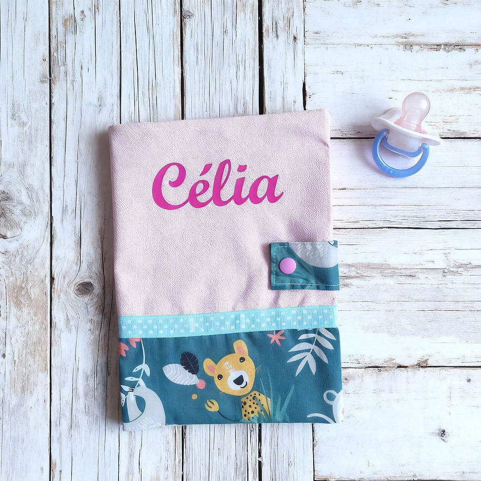 Protège carnet de santé en coton rose et coton vert imprimé d'animaux avec le prénom "Célia" floqué en fuchsia.
