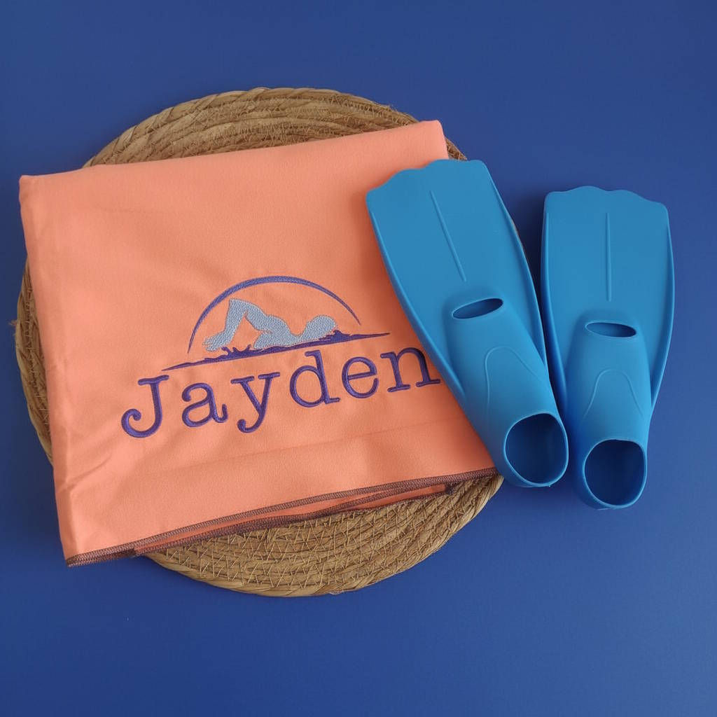 Serviette de sport en microfibre orange brodée d'un nageur et du prénom "Jayden" en bleu roi.