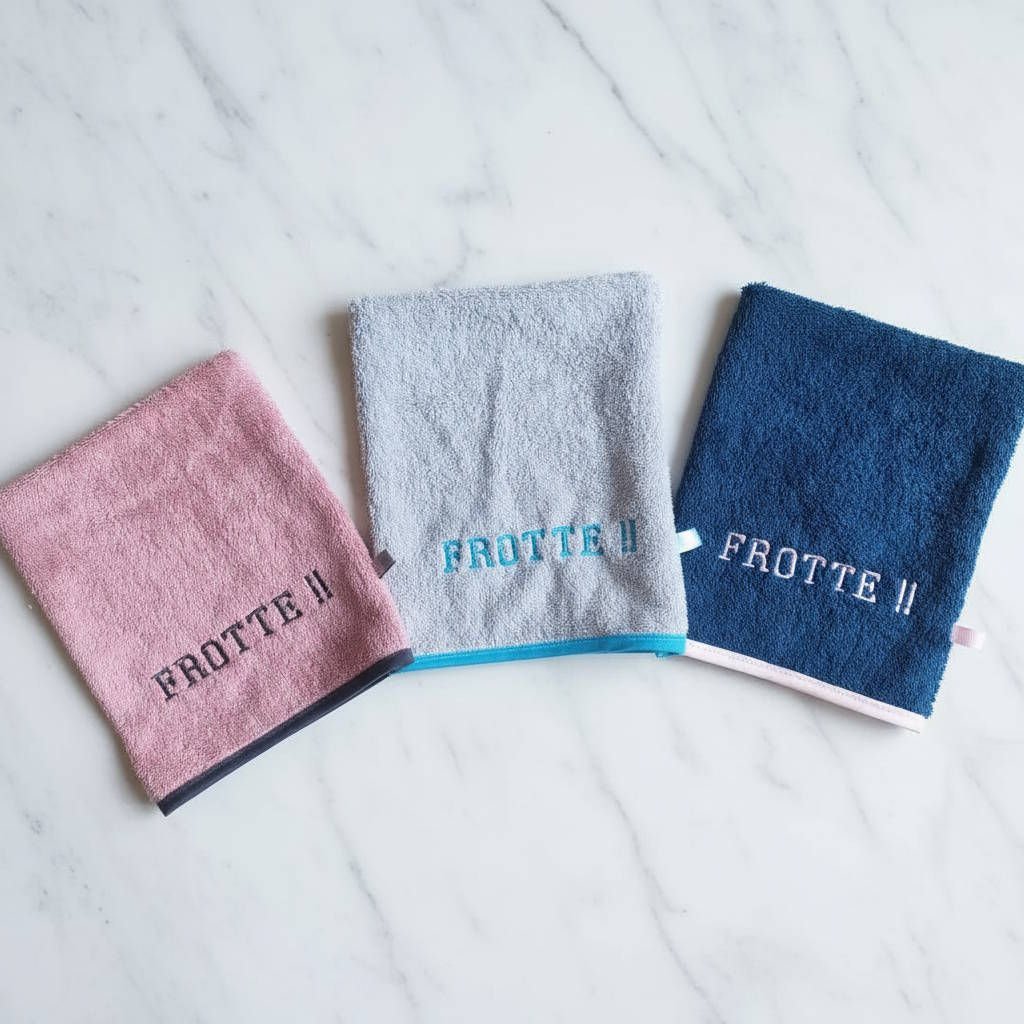 trois gants de toilettes brodés avec l'expression "Frotte !!"