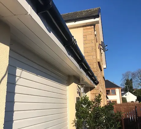 an outside of a cream and white house showcasing the work we done which is new fascia,soffit and guttering