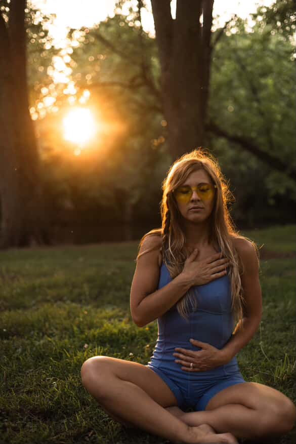 Woman meditating in nature at sunset